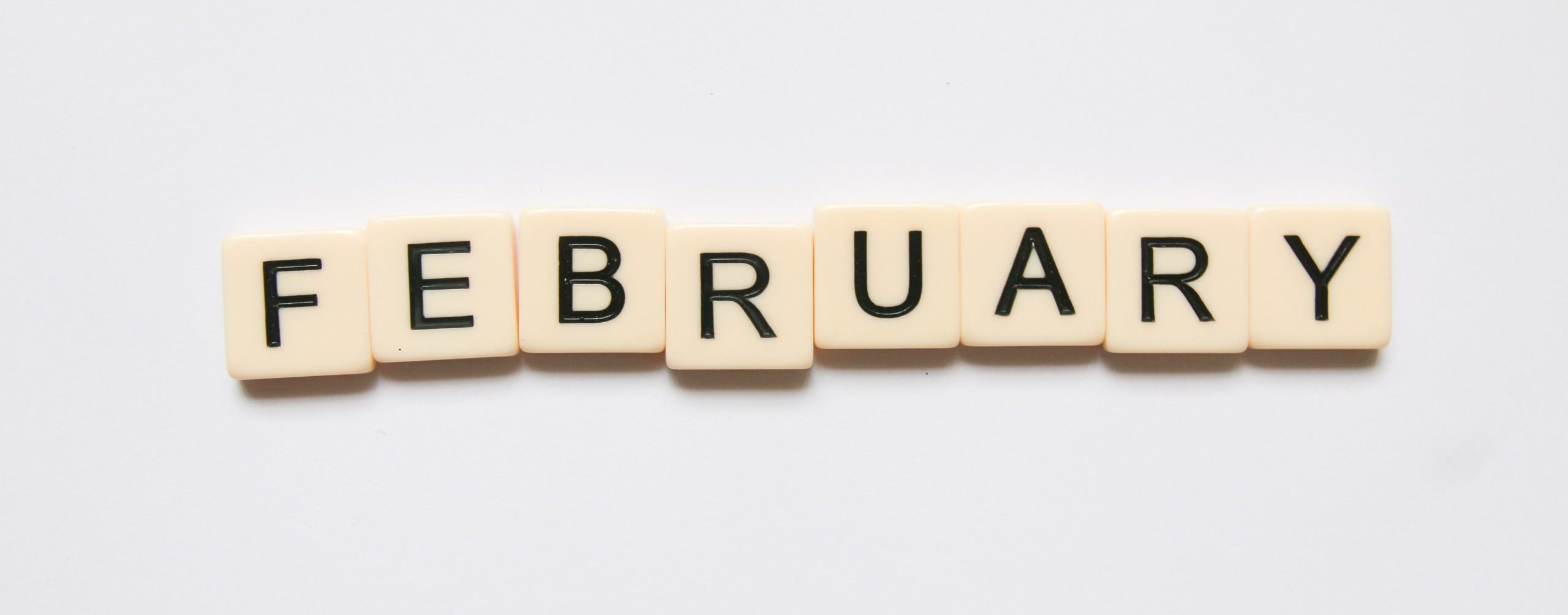 february spelled out in scrabble tiles